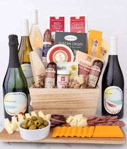 Wooden basket filled with 4 cheeses, 3 sausages, crackers, cookies, nuts, mustard, olives and crisps alongside 4 bottles of wine - Pinot Noir, Chardonnay, Ros&eacute; &amp; Sparkling Wine.
